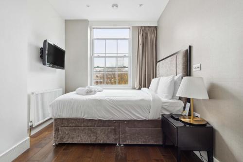 a bedroom with a large bed and a window at Golden Square Soho in London