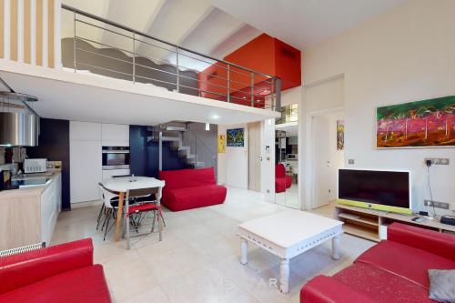 un salon avec des canapés rouges et une cuisine dans l'établissement Loft Gambetta 33 Fshh, à Nice