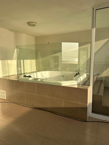 a bath tub in a room with a glass wall at Departamento Playa Brava 3D 2B in Iquique