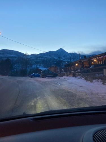 een autoraam met uitzicht op een straat met sneeuw bij All’angolo delle alpi in Montoso