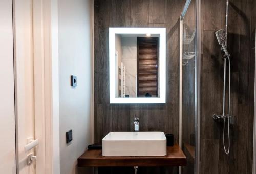 uma casa de banho com um lavatório branco e um espelho. em VIP apart 712 em Tbilisi