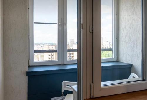 um quarto com duas janelas e uma parede azul em VIP apart 712 em Tbilisi