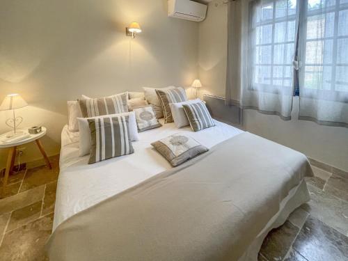 un grand lit blanc dans une chambre avec une fenêtre dans l'établissement Mas du Murier, à Correns