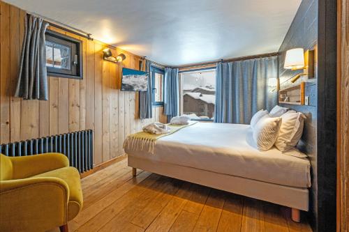 een slaapkamer met een bed, een stoel en een raam bij Chalet Carte Blanche Thovex in Val dʼIsère