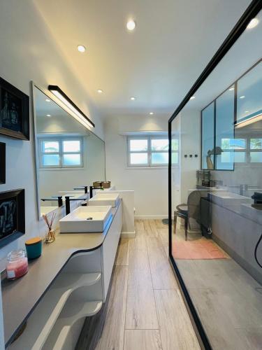 La salle de bains est pourvue de 3 lavabos et d'une rangée de miroirs. dans l'établissement Biarritz, Castellamare, Magnifique maison avec piscine, à Biarritz