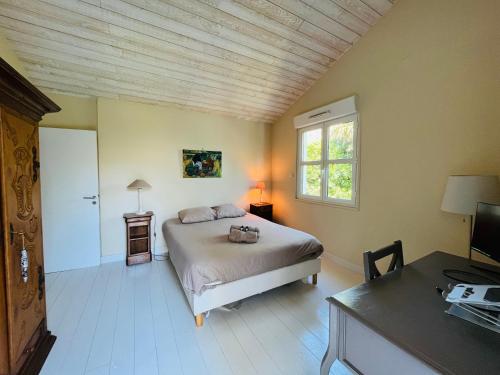 a bedroom with a bed and a desk and a window at Biarritz, Castellamare, Magnifique maison avec piscine in Biarritz