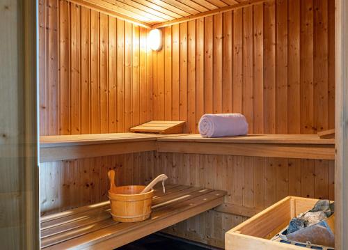 a wooden sauna with a bucket on a shelf at Chalet Carte Blanche Thovex in Val-d'Isère