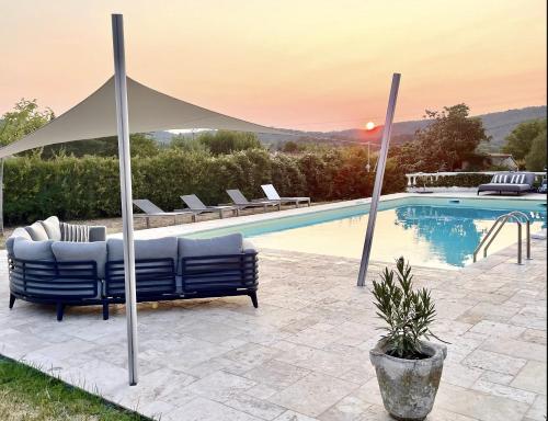 - une piscine avec 2 chaises longues et un parasol dans l'établissement Mas du Murier, à Correns