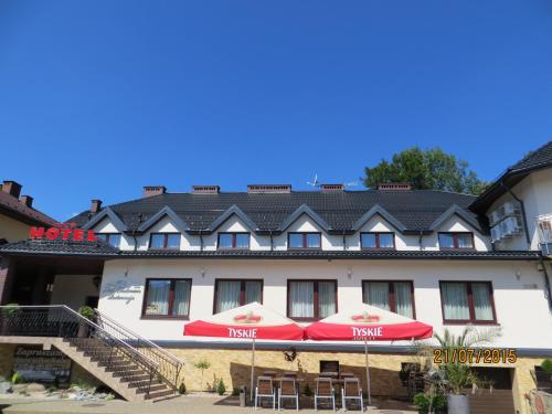 un hôtel avec deux parasols rouges devant lui dans l'établissement Hotel Pod Chełmem, à Ropa