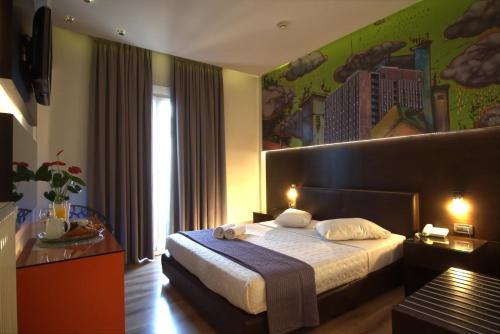 a hotel room with a bed and a painting on the wall at Athens City Hotel in Athens