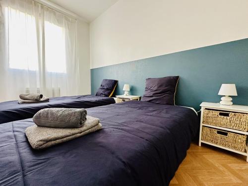 deux lits dans une chambre aux murs bleus dans l'établissement Maison mitoyenne au calme quartier de la Pironniere 4 pers, à Les Sables-dʼOlonne