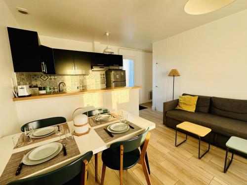 une cuisine et un salon avec une table et un canapé dans l'établissement Maison mitoyenne au calme quartier de la Pironniere 4 pers, à Les Sables-dʼOlonne