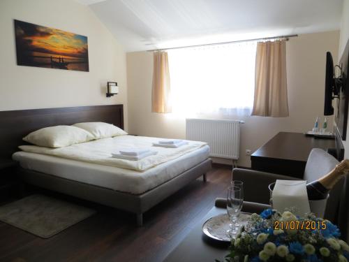 a bedroom with a bed and a table and a desk at Hotel Pod Chełmem in Ropa