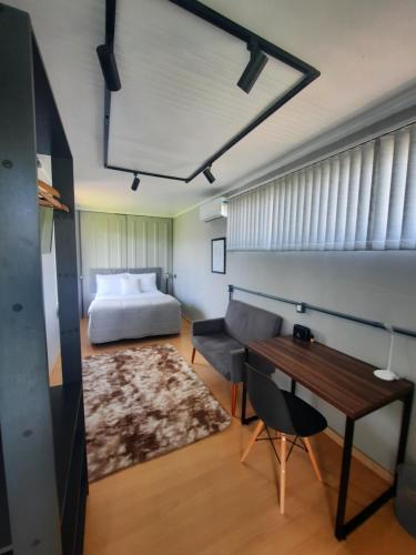 1 dormitorio con cama, mesa y escritorio en Container Guesthouse - 1 en Urubici