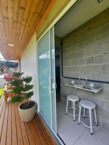 una terraza con fregadero y 2 taburetes en Container Guesthouse - 1 en Urubici