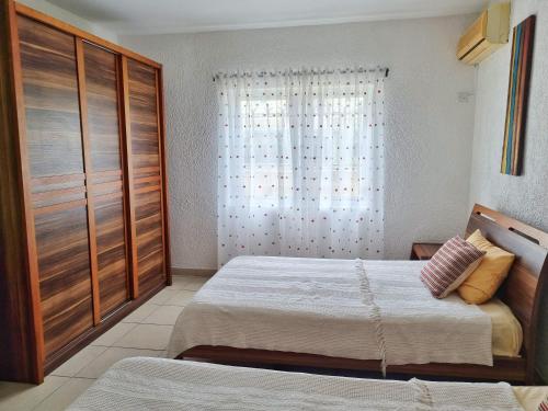 a bedroom with two beds and a window at C9 Tamarinier in Flic-en-Flac