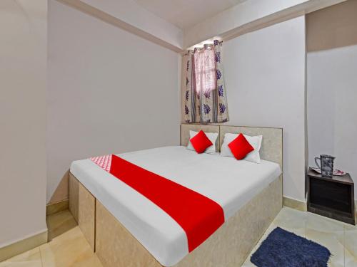 蘭契的住宿－OYO Flagship Sona Residency，一间卧室配有一张带红色枕头的大床