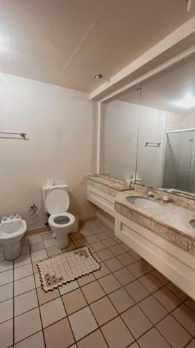 a bathroom with a toilet and a tub and a sink at FLAT EM ALPHAVILLE in Barueri