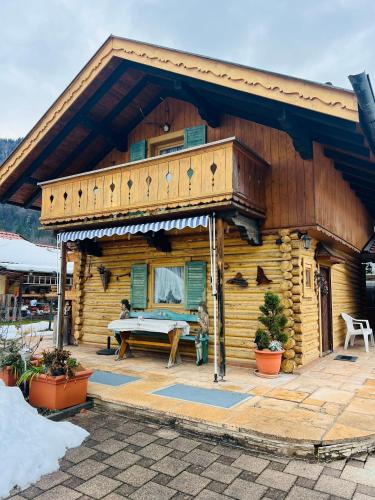 uma cabana de madeira com um alpendre e uma mesa em Hexen Haus em Oberau