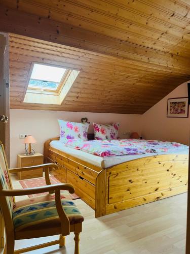 a bedroom with a wooden bed and a chair at Hexen Haus in Oberau