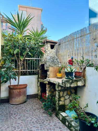 a garden with potted plants and a stone fireplace at Dea's House con parcheggio in Gaeta