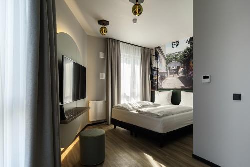 a hotel room with a bed and a television at Vienna House Easy by Wyndham Berlin Potsdamer Platz in Berlin