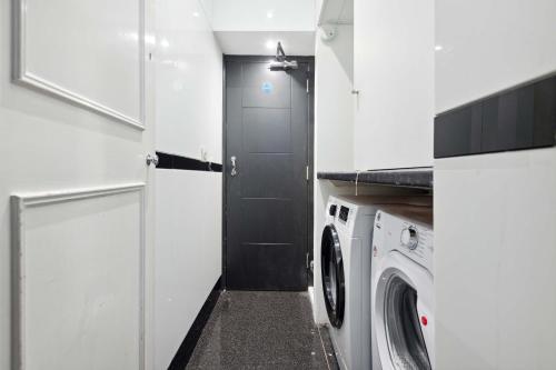 a kitchen with a washing machine and a door at Golden Square Soho in London