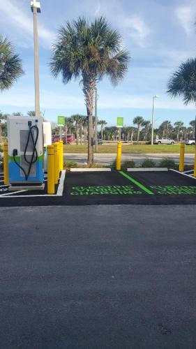 a parking lot with a recycling machine and palm trees at Holiday Inn Express St. Augustine - Vilano Beach by IHG in Saint Augustine