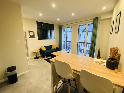 a kitchen with a table and chairs and a living room at Le Faubourg in Rodez