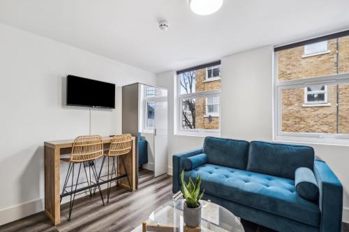 a living room with a couch and a table at Sutherland Apartments in London