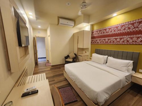 a bedroom with a large bed and a tv at SHAMUKA HOTEL in Puri