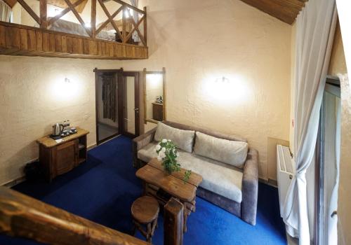 a living room with a couch and a table at Drevny Grad Park-hotel in Lviv