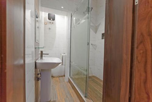 a bathroom with a glass shower and a sink at God's Touch Apartments Remi Fani Kayode GRA. Ikeja in Ikeja