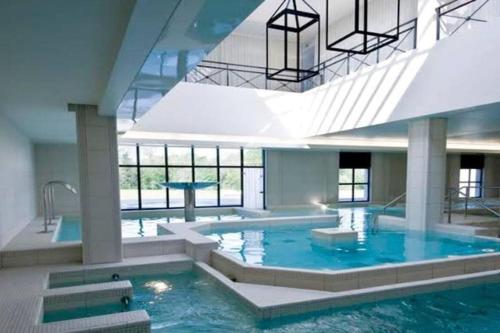 une grande piscine avec de l'eau bleue dans un immeuble dans l'établissement 