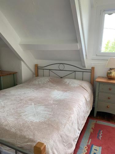 1 dormitorio con cama, mesa y ventana en La maison de l'étang, en Ploërdut