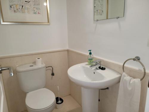 a bathroom with a white toilet and a sink at NPG429 - Holiday Beach House on the Golf Course in Huelva