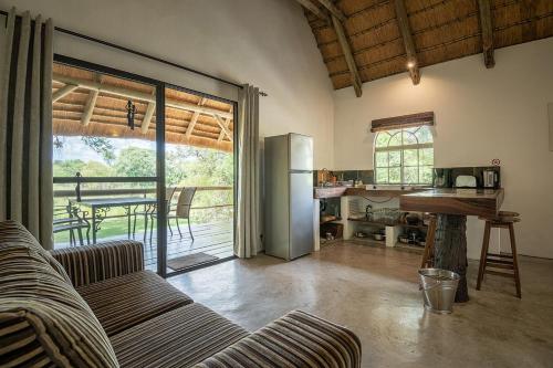 a living room with a couch and a kitchen at Mobola Lodge in Mamono