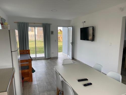 Una sala de estar con una mesa y sillas blancas. en Bruma Mia, en San Clemente del Tuyú