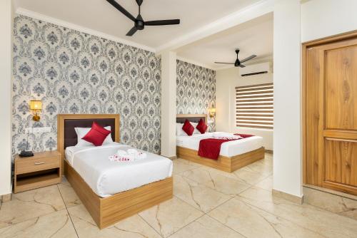 een slaapkamer met 2 bedden en een muur bij ESAA Airport Hotel Kochi in Cochin