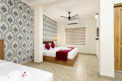 a bedroom with two beds with red pillows at ESAA Airport Hotel in Cochin