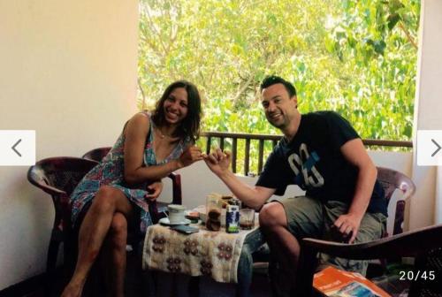 a man and a woman sitting at a table holding hands at Raymond Place -REDSTAR in Weligama