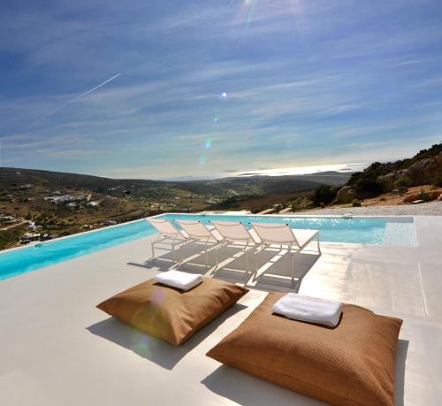 two chairs and pillows on a swimming pool at Pili Pala Suites in Episkopianá