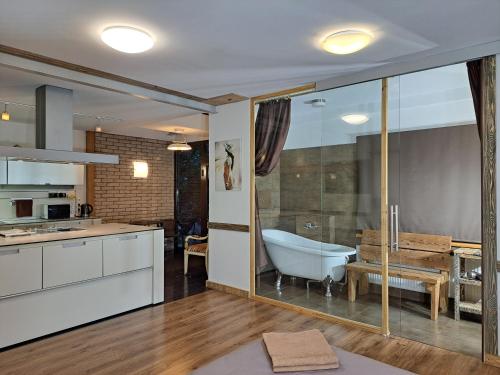 a bathroom with a bath tub and a kitchen at Champêtre Park View Apartments in Rīga