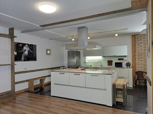 a kitchen with white cabinets and a kitchen island at Champêtre Park View Apartments in Rīga