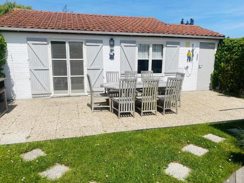 a patio with a table and chairs in front of a building at Zeepark Zeewind in Bredene