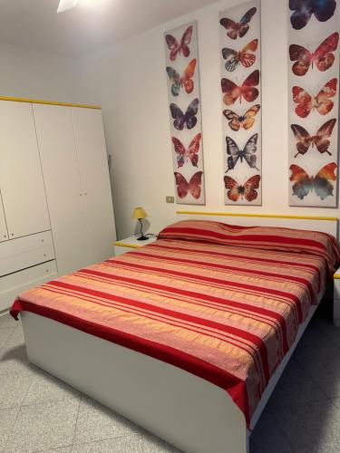 sypialnia z łóżkiem z motylami na ścianie w obiekcie Appartamento Porto Azzurro 5/6 beds w mieście Porto Azzurro