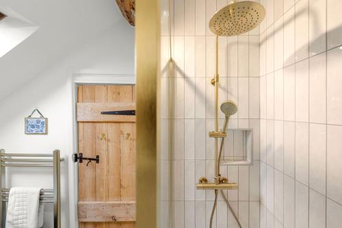 a bathroom with a shower with a wooden door at Welsh Cottage in Little Marcle