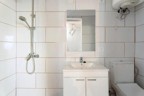 a white bathroom with a shower and a sink at Apartamento El Moral in Frontera