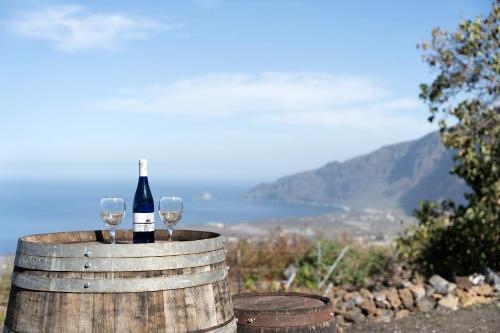 a bottle of wine and two glasses on a barrel at Apartamento El Moral in Frontera