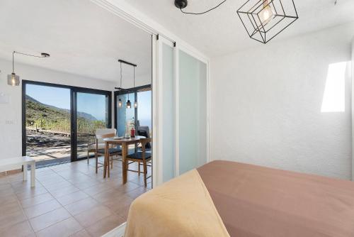 a bedroom with a bed and a dining room with a table at Apartamento El Moral in Frontera